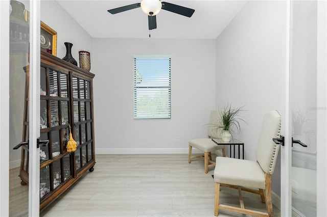 sitting room with ceiling fan and light hardwood / wood-style flooring