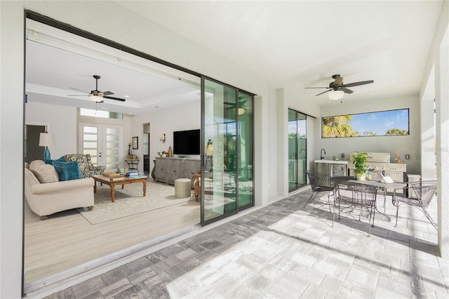 sunroom featuring ceiling fan and french doors