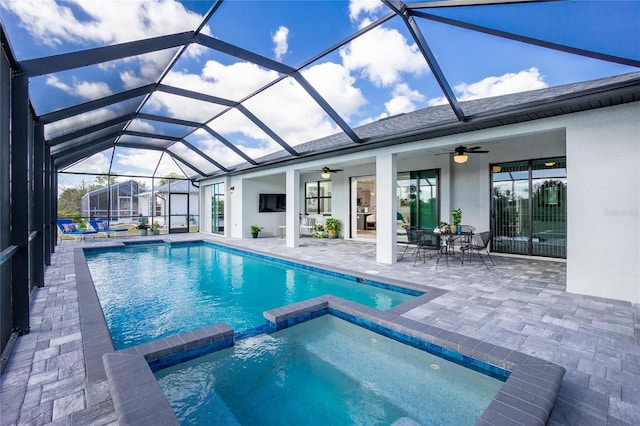 view of swimming pool with ceiling fan, a lanai, an in ground hot tub, and a patio