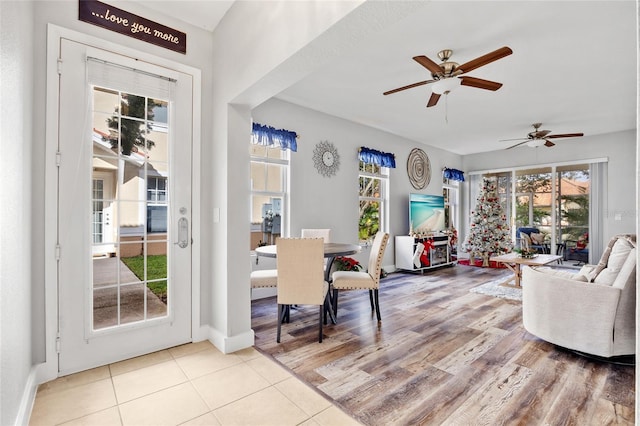 living room with light tile patterned floors, plenty of natural light, and ceiling fan