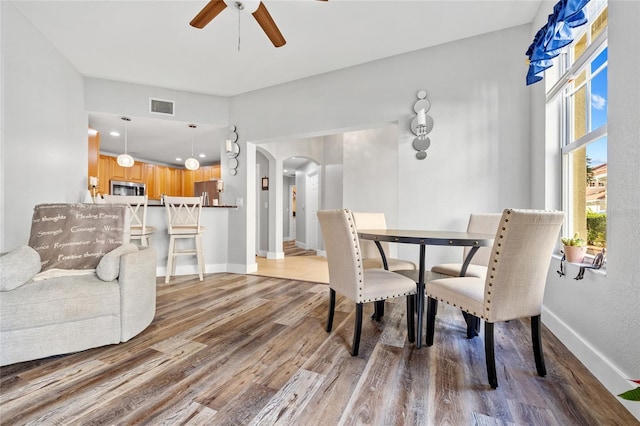 dining area with light hardwood / wood-style floors and ceiling fan