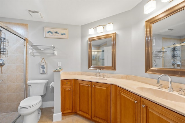 bathroom featuring tile patterned floors, vanity, toilet, and a shower with door