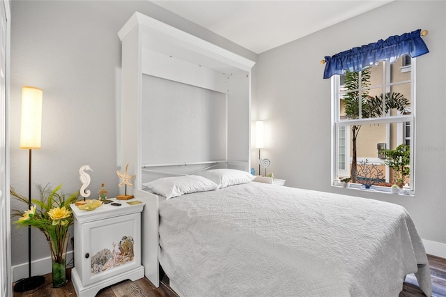 bedroom with dark wood-type flooring