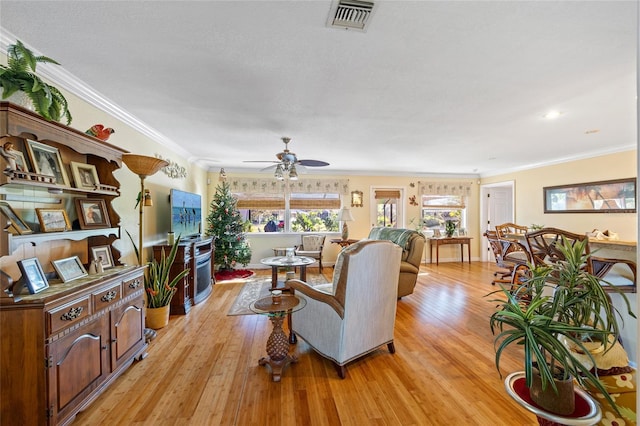 living room featuring ceiling fan, light hardwood / wood-style floors, and ornamental molding