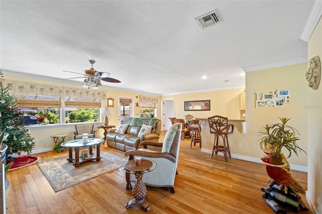 living room featuring ceiling fan, light hardwood / wood-style floors, and ornamental molding