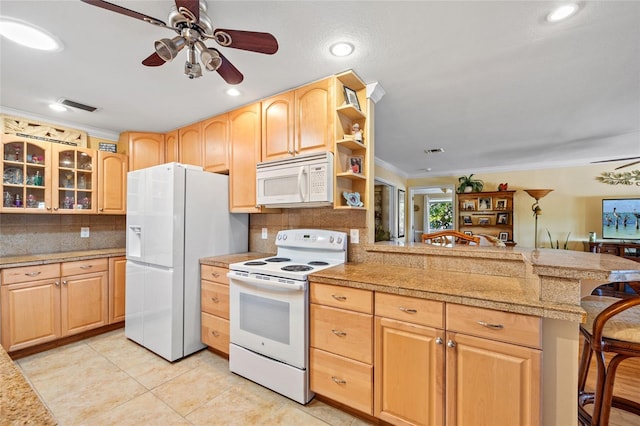 kitchen featuring a kitchen bar, white appliances, kitchen peninsula, and ornamental molding