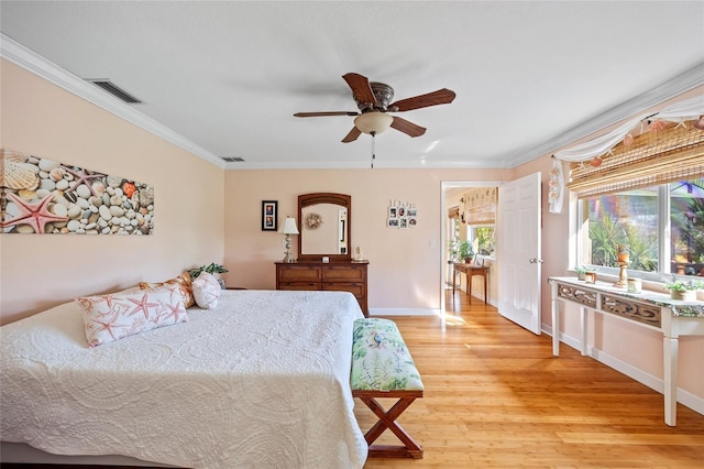 bedroom featuring multiple windows, ceiling fan, ornamental molding, and light wood-type flooring