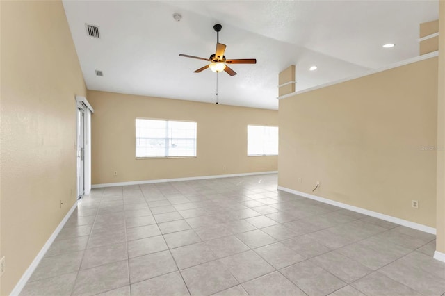 spare room with ceiling fan, light tile patterned floors, and lofted ceiling