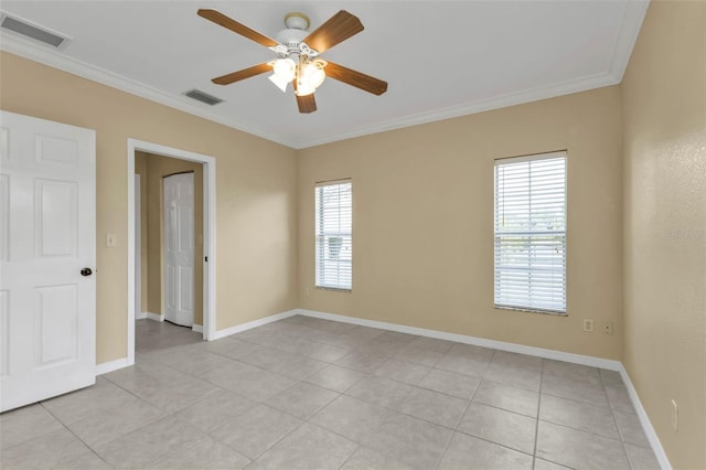 tiled empty room featuring ceiling fan and crown molding