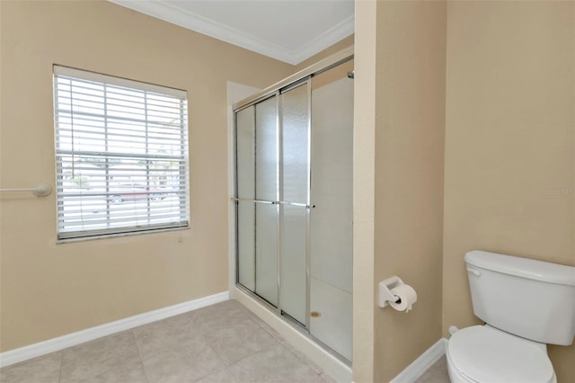 bathroom featuring tile patterned flooring, toilet, a shower with door, and ornamental molding