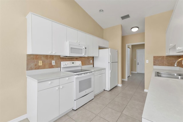 kitchen featuring decorative backsplash, white appliances, sink, white cabinetry, and lofted ceiling