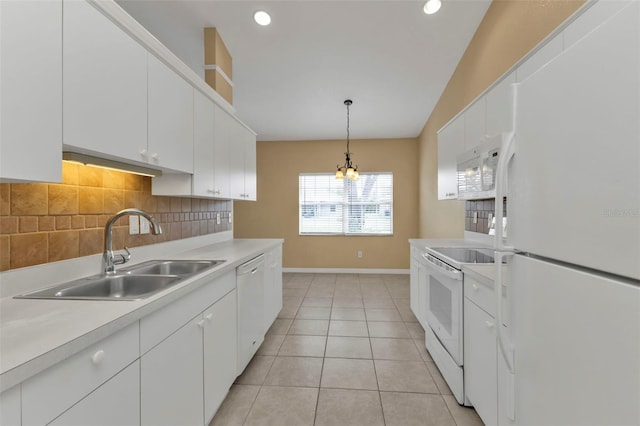 kitchen featuring lofted ceiling, white appliances, sink, decorative light fixtures, and white cabinetry