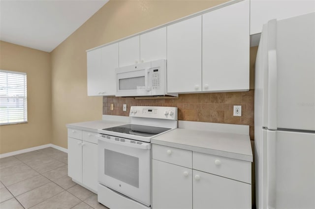 kitchen with decorative backsplash, white appliances, white cabinets, lofted ceiling, and light tile patterned flooring