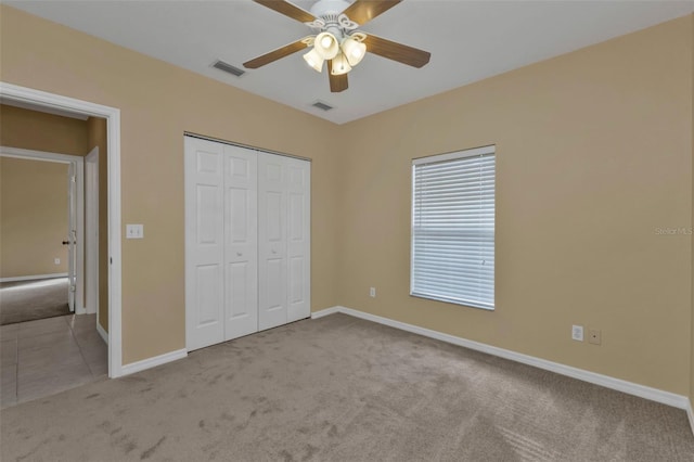 unfurnished bedroom with ceiling fan, a closet, and light colored carpet