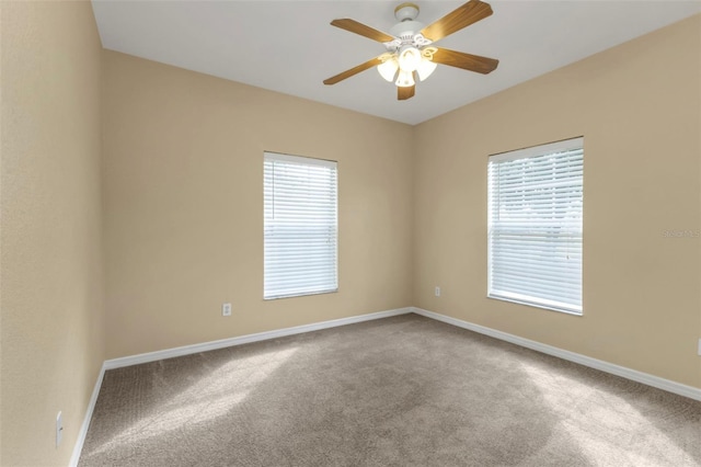 carpeted empty room featuring plenty of natural light and ceiling fan