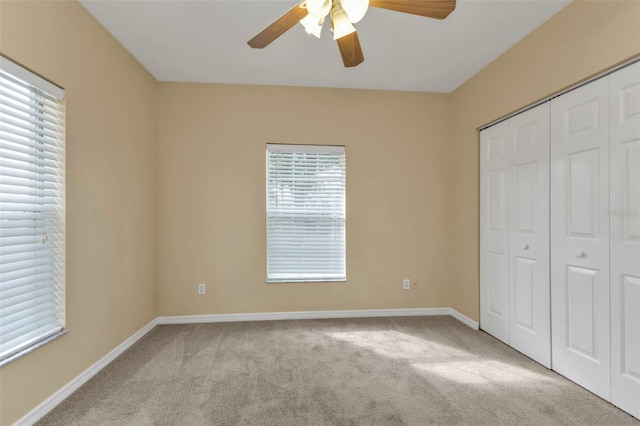 unfurnished bedroom with light carpet, a closet, and ceiling fan