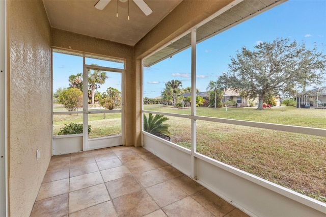 unfurnished sunroom featuring ceiling fan