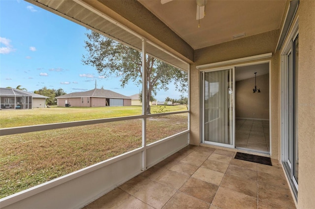 unfurnished sunroom featuring ceiling fan