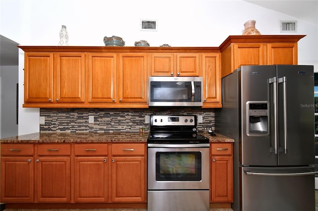 kitchen with backsplash, dark stone counters, and appliances with stainless steel finishes