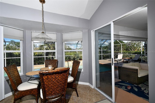 tiled dining area featuring a textured ceiling and lofted ceiling