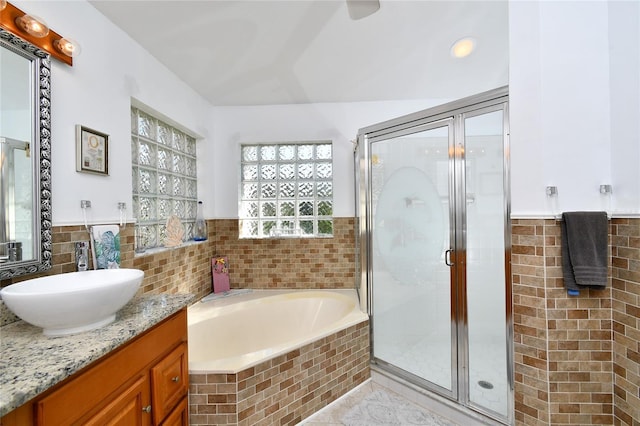 bathroom featuring shower with separate bathtub and vanity