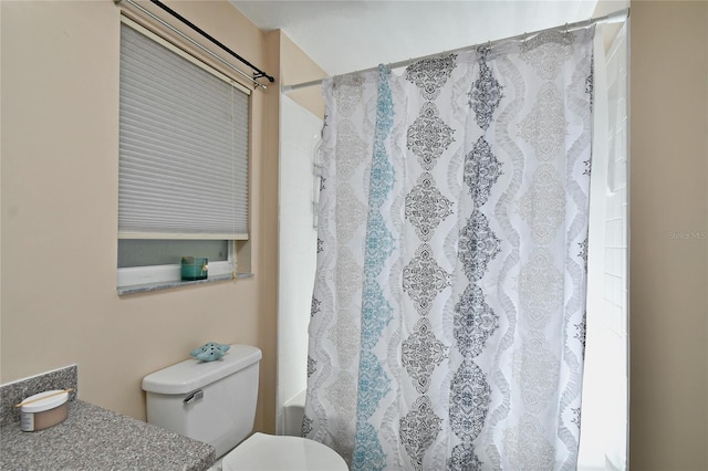 bathroom featuring shower / bath combo with shower curtain and toilet