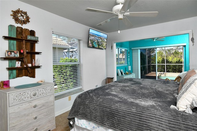 carpeted bedroom with access to exterior, ceiling fan, and a textured ceiling