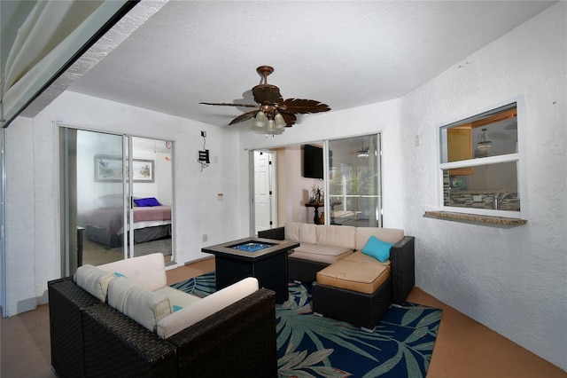 living room with ceiling fan and a textured ceiling