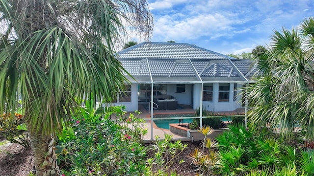 rear view of property with a lanai and a patio