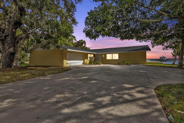 view of front facade featuring a garage, concrete driveway, and stucco siding