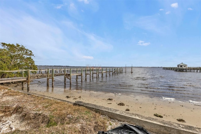 dock area featuring a water view and a view of the beach