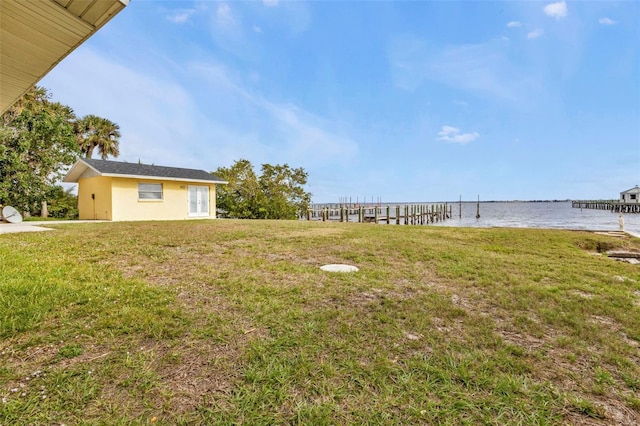 view of yard with a water view and a boat dock