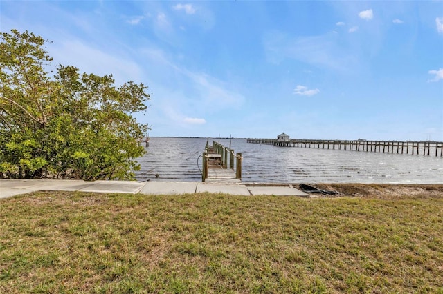 dock area featuring a lawn and a water view