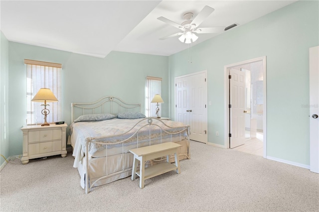 bedroom featuring ensuite bath, ceiling fan, and light colored carpet