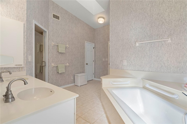 bathroom with tile patterned flooring, vanity, shower with separate bathtub, and a skylight