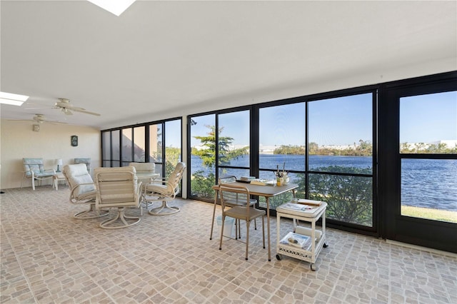 sunroom with ceiling fan, a healthy amount of sunlight, and a water view