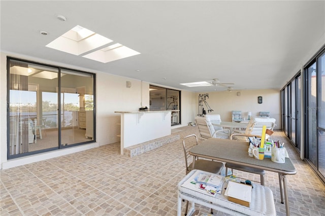 dining space featuring ceiling fan and a skylight