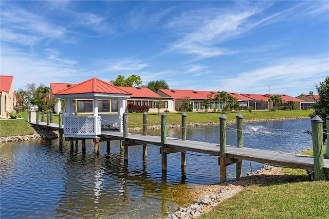 dock area with a gazebo, a yard, and a water view