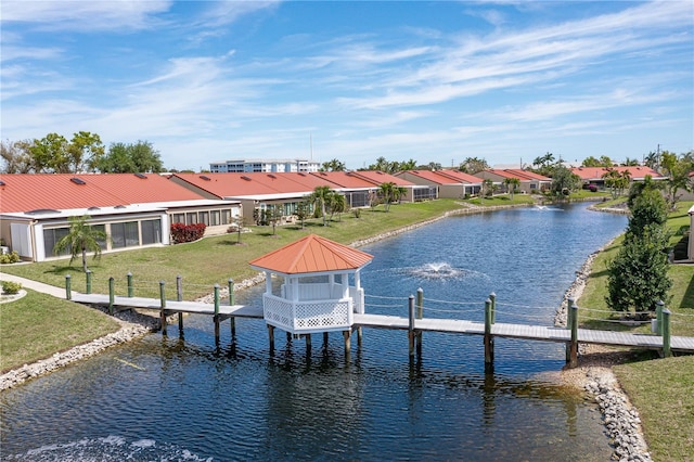 view of dock featuring a gazebo, a water view, and a lawn