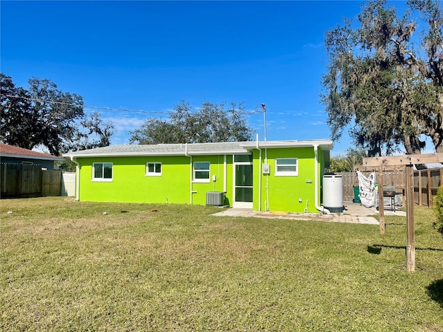 rear view of house with a yard, central AC unit, and a patio area