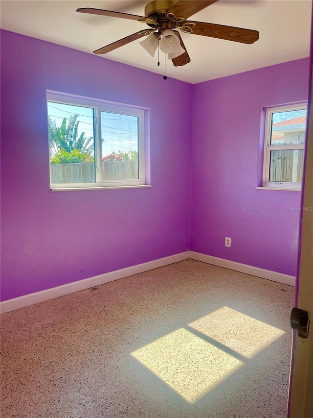 spare room with a wealth of natural light and ceiling fan