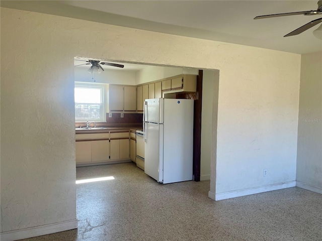 kitchen featuring ceiling fan, sink, white appliances, and cream cabinetry