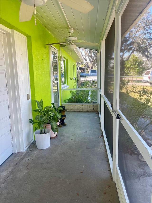 unfurnished sunroom with ceiling fan