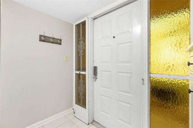 entryway featuring a textured ceiling and light tile patterned flooring