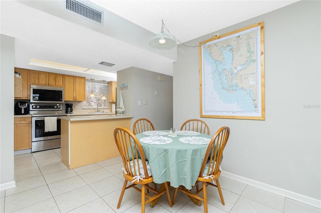 dining area featuring sink and light tile patterned flooring