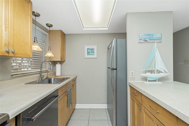 kitchen with sink, stainless steel appliances, a textured ceiling, decorative light fixtures, and light tile patterned floors