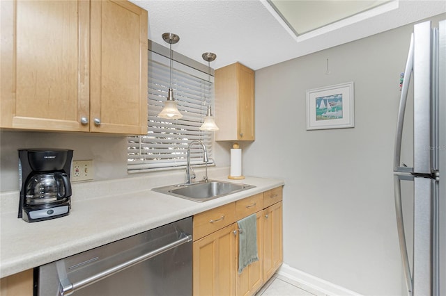 kitchen with stainless steel dishwasher, pendant lighting, sink, and light brown cabinetry