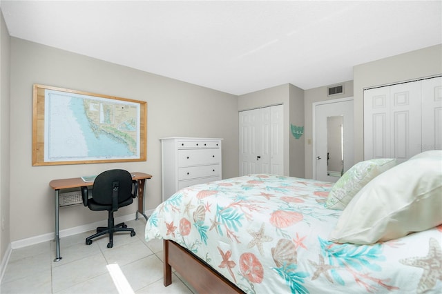 tiled bedroom featuring multiple closets