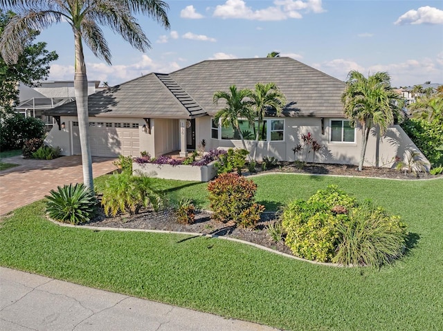 ranch-style home featuring a garage and a front lawn