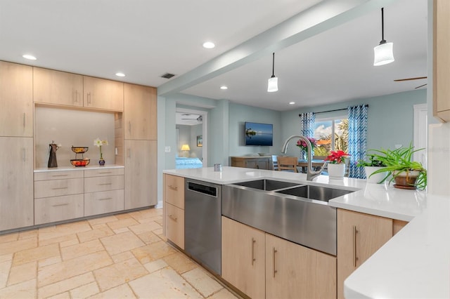 kitchen with light brown cabinetry, hanging light fixtures, stainless steel dishwasher, and sink